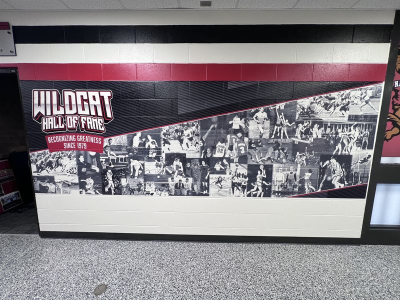Wildcat Hall of Fame collage, Recognizing Greatness Since 1979, printed on a painted block wall