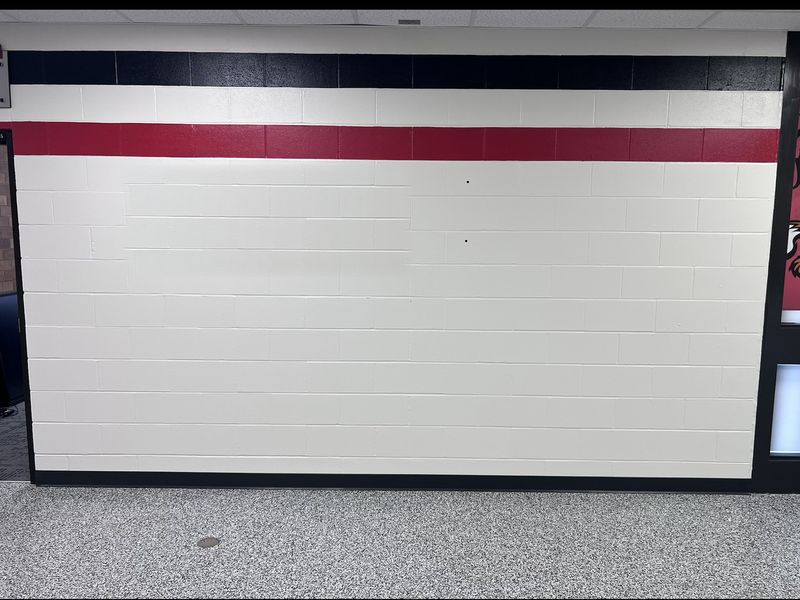 Before: bare painted block wall in the Blikre Activity Center